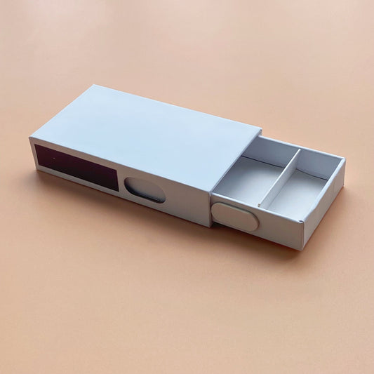 Child-resistant paper box with built-in match compartment for cannabis or wellness products, sustainable and custom-branded packaging design.