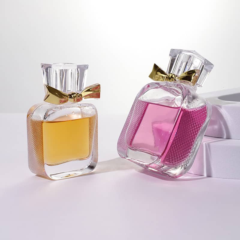 Cosource flat glass perfume bottle 50ml with gold bow cap in pink and amber liquid