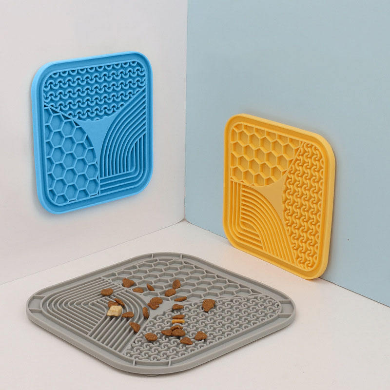 Blue silicone lick pad for dogs with suction cups attached to bathroom tile