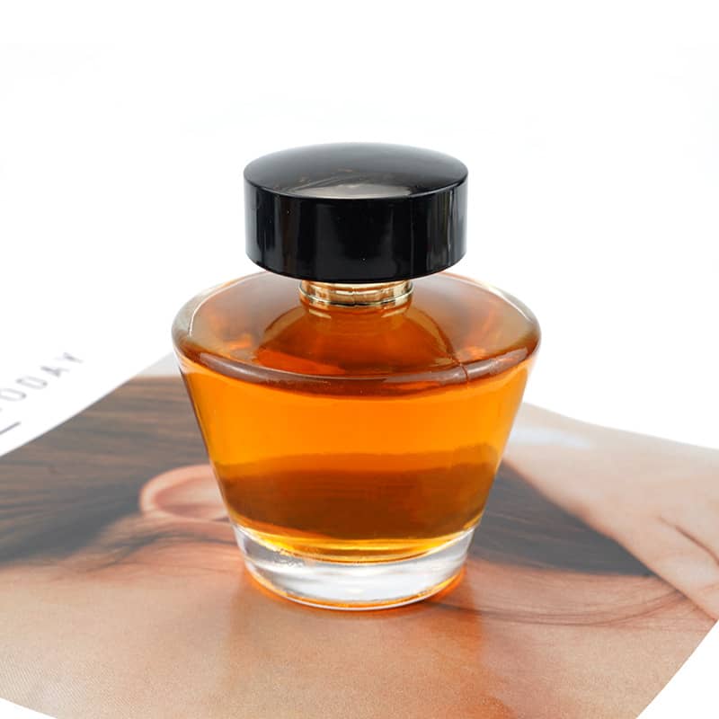 Cosource cone shaped glass perfume bottle filled with amber liquid and black cap